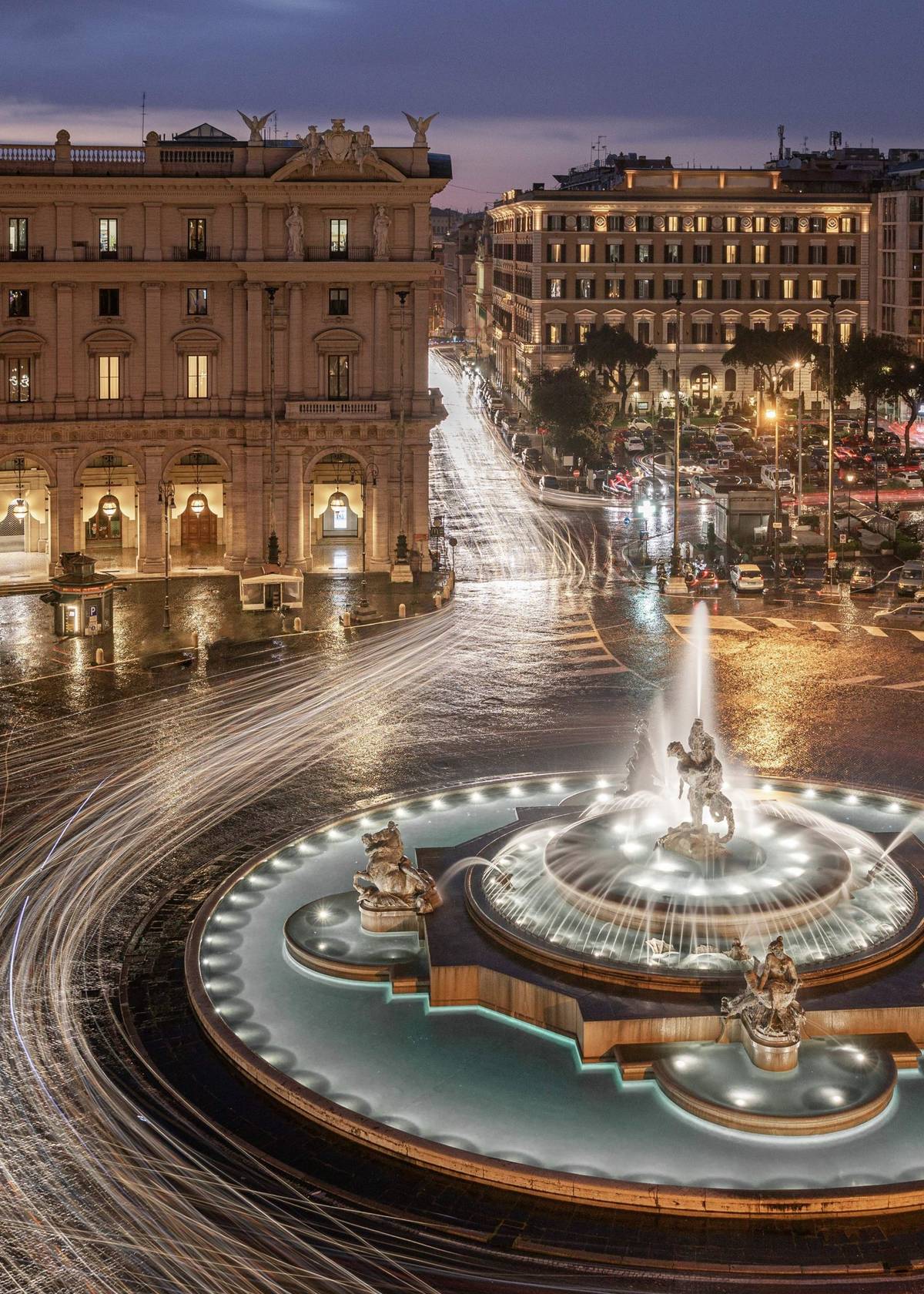 La Fontana delle Naiadi di notte, in Piazza della Repubblica, con le scie delle luci delle auto.